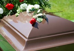 Stock image of flowers on top of a casket.