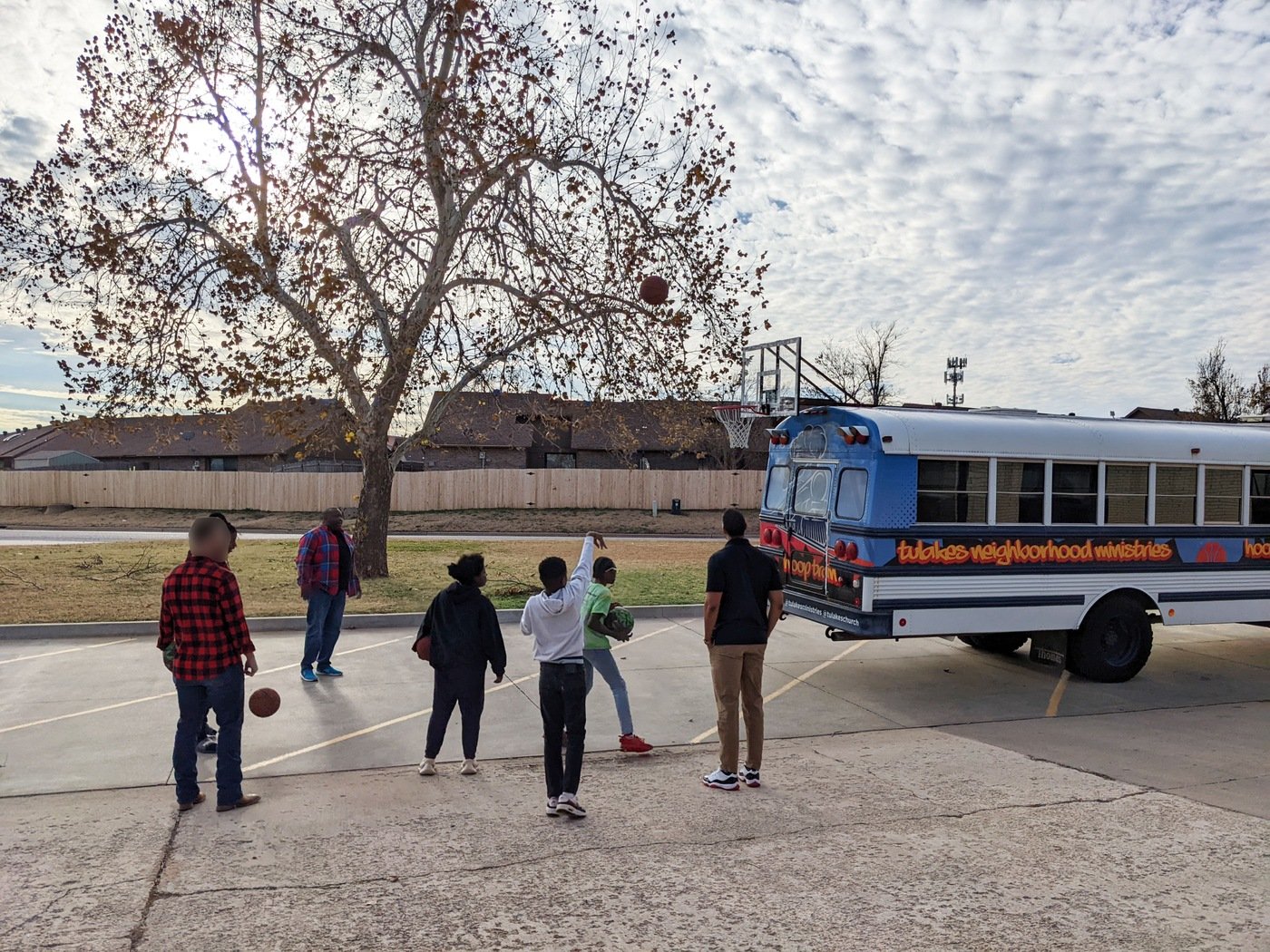FBI personnel and kids shoot baskets on a hoop attached to a bus run by Tulakes Ministries in Bethany, Oklahoma. The ministry's pastor, Thaddeus Black, received FBI Oklahoma City's 2023 Director's Community Leadership Award.
