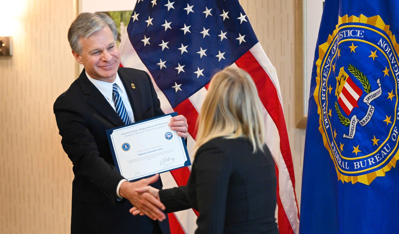 Director Christopher Wray shakes the hand of an FBI National Command Course graduate during a graduation ceremony held on July 14, 2023.
