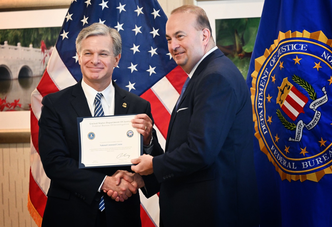 Director Christopher Wray poses for a photo with a graduate of the fifth session of the FBI National Command Course on July 14, 2023.