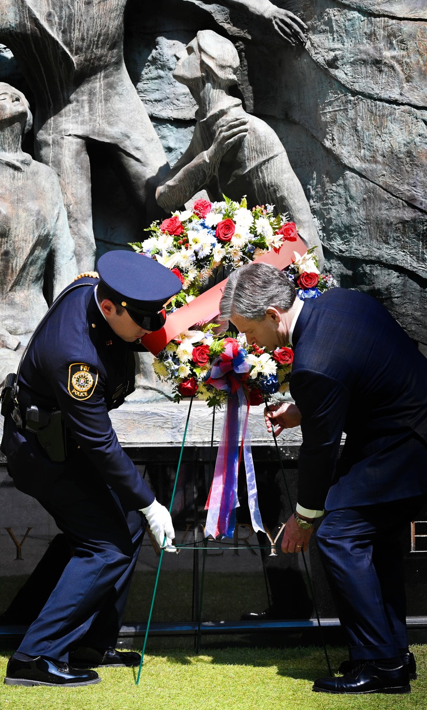 FBI Director Christopher Wray helps lay a wreath during a Special Agent Memorial Service at FBI Headquarters on May 11, 2023. 