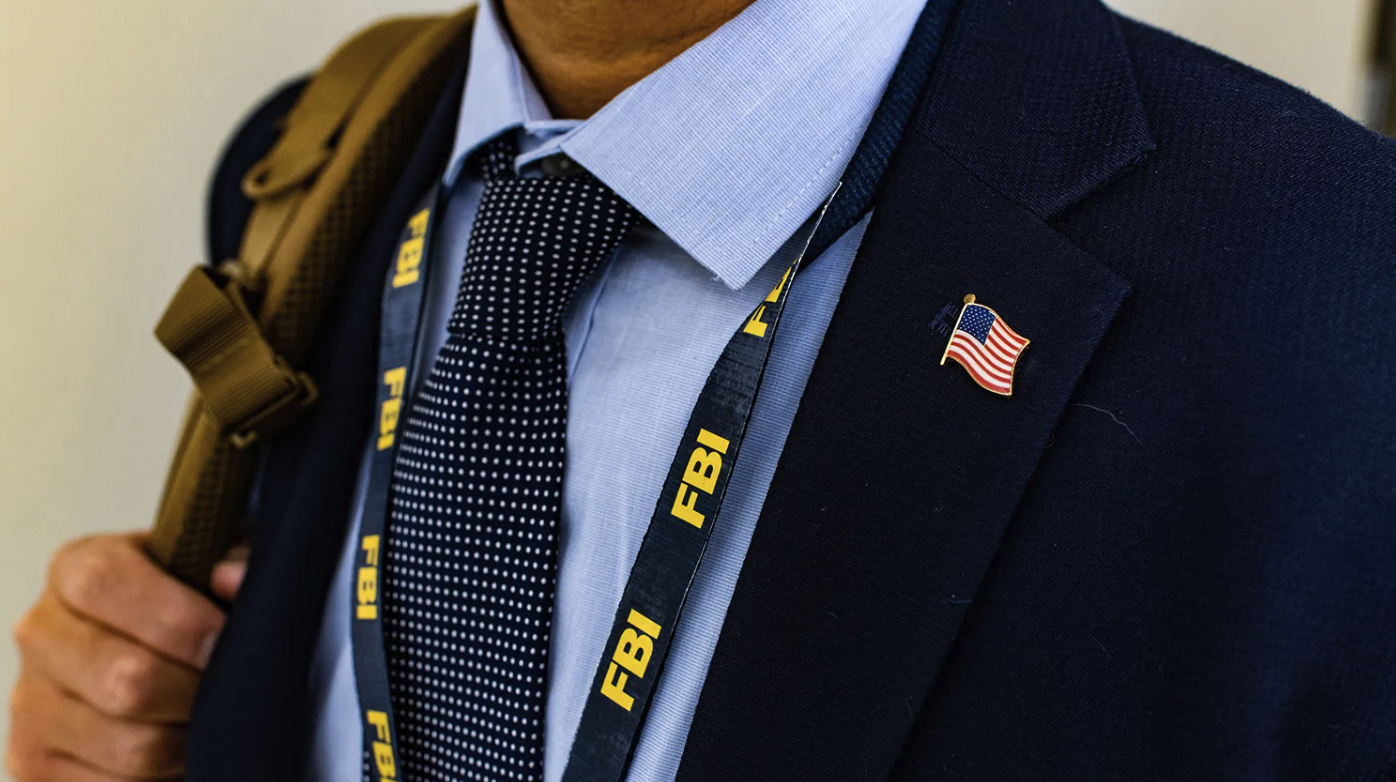 Photo of an FBI employee wearing an FBI lanyard with a US flag lapel pin