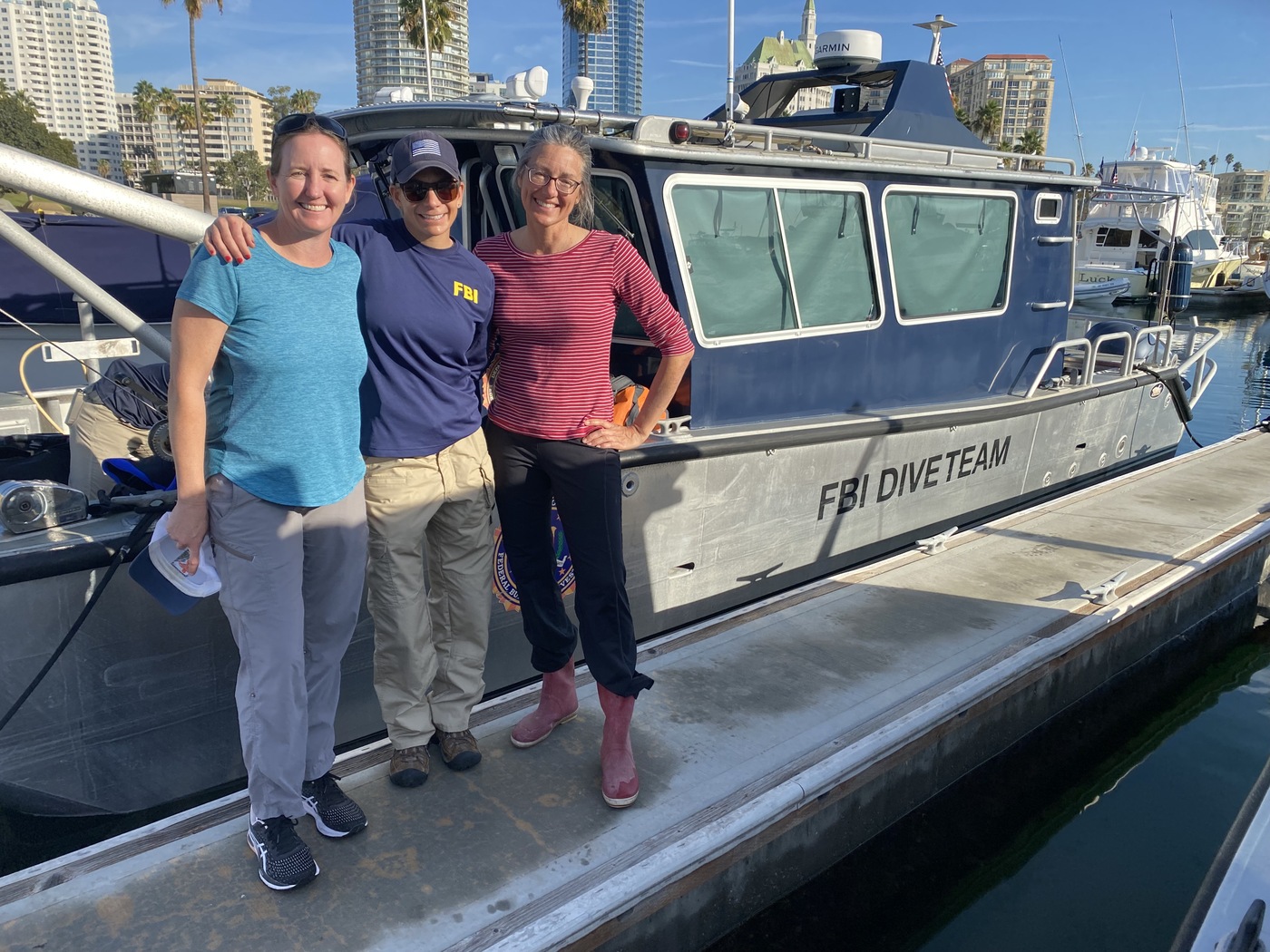 A member of the USERT team poses with the BOEM divers, Susan Zeleski (left) and Donna Schroeder (right).