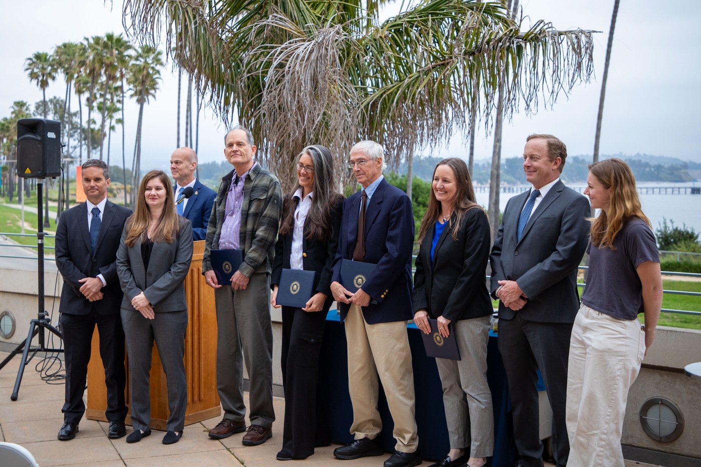 Members of the investigative team pose for photos at the Director's Awards ceremony, hosted at UC Santa Barbara. From left to right, USERT lead Ty Summers, SA Ketrin Adam, ASAC Sean Hoard, Dr. Guy Cochrane, Donna Schroeder, Dr. Mark Page, Susan Zaleski, AUSA Matt O'Brien, and lab technician Makenna Colucci.