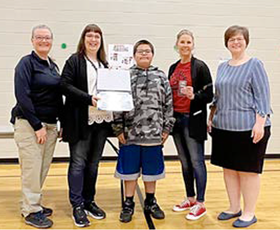 FBI Minneapolis presented an award to Longfellow Elementary School for its outstanding performance in the Safe Online Surfing Program in December 2022. This is the third time the school has received this award. Above, a student receives an award for scoring 100% on the exam two years in a row.