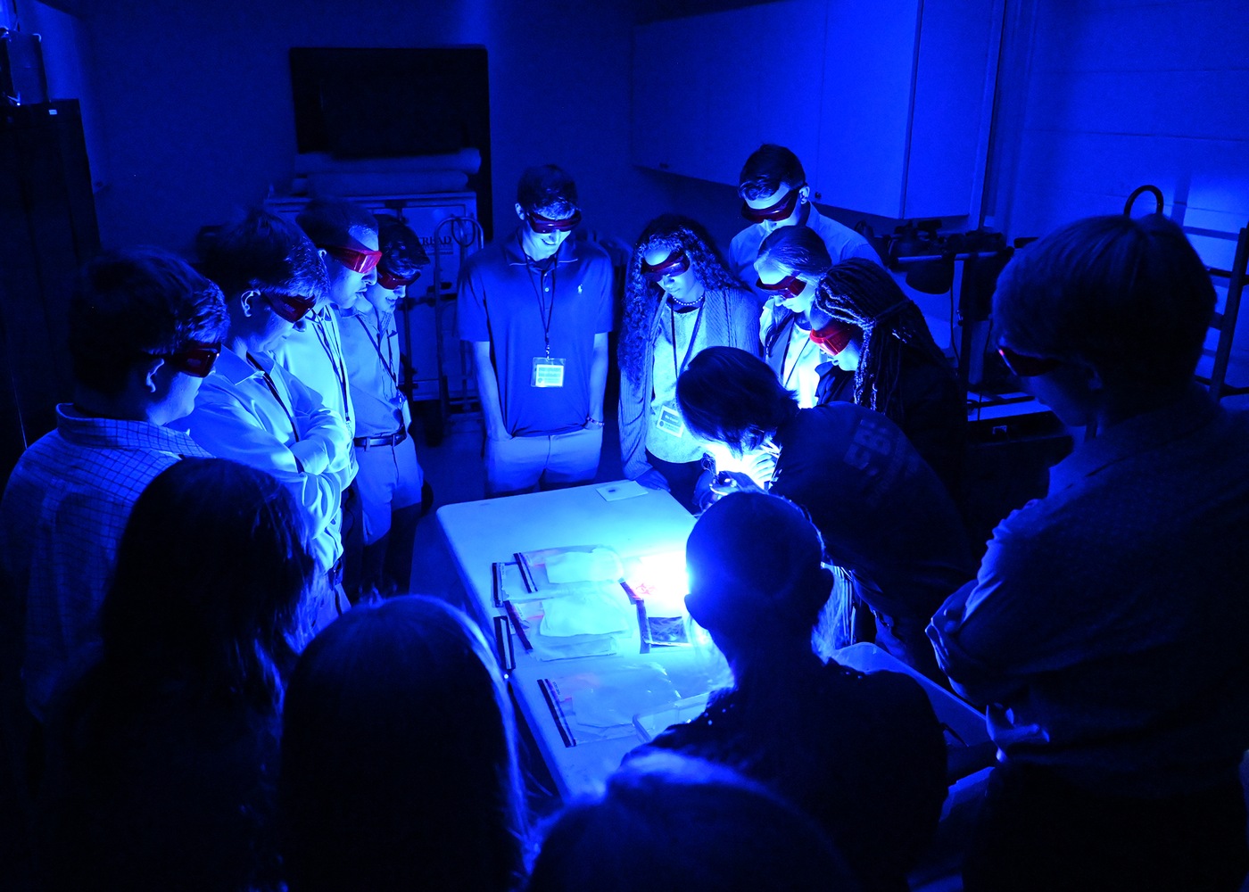 Students in FBI Mobile's Teen Academy look at alternate light sources and learn about their role in criminal investigations. 
