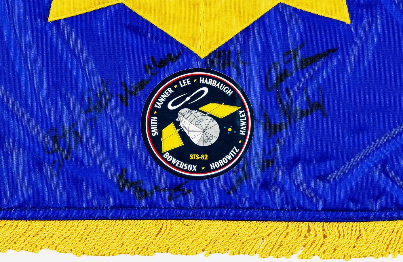 A seal from the space flight is attached to the FBI flag with autographs from each astronaut. Steve’s signature is on the far left. Every space flight has its own uniquely designed seal.