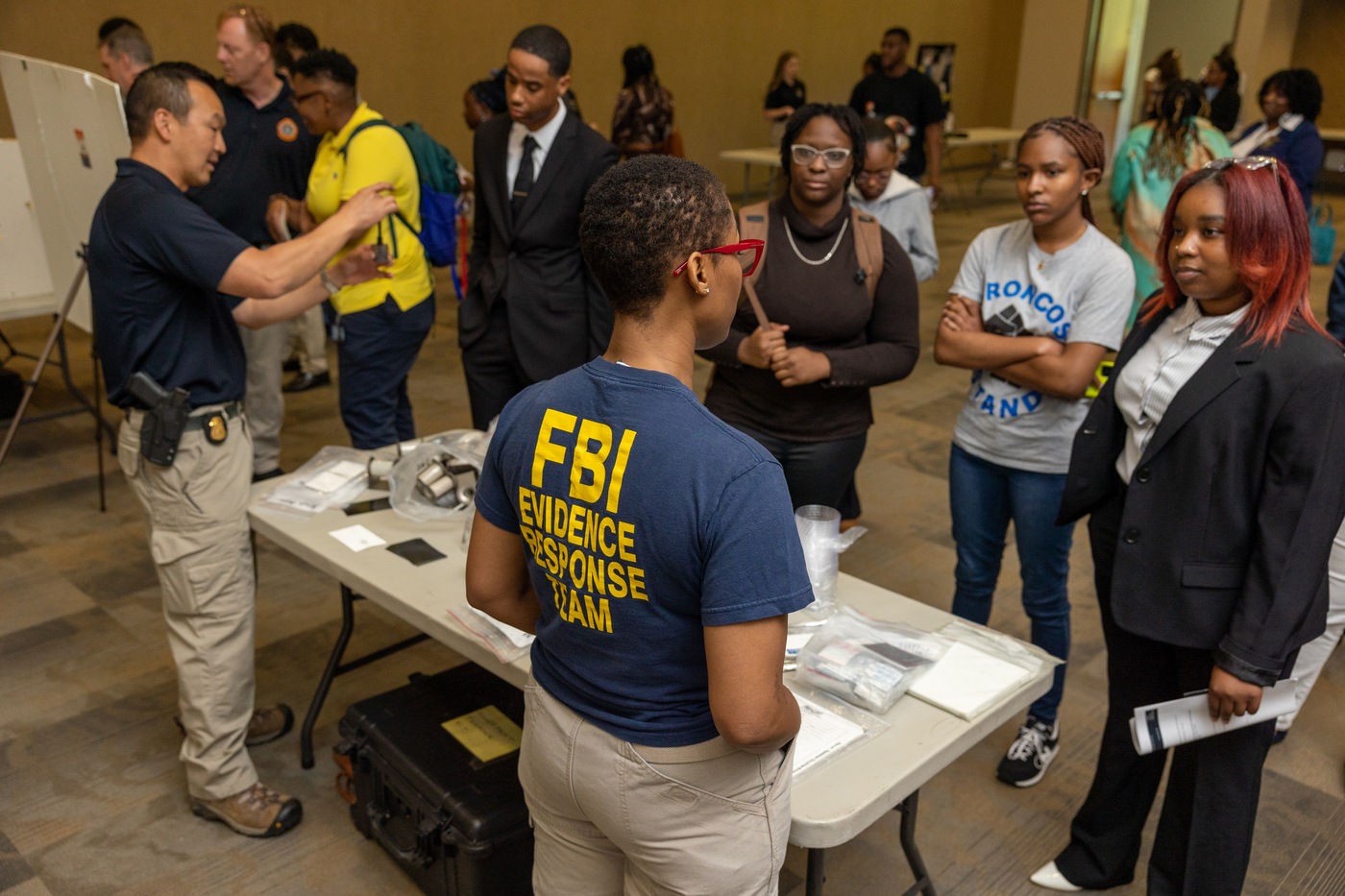 FBI personnel are shown while speaking with college students.