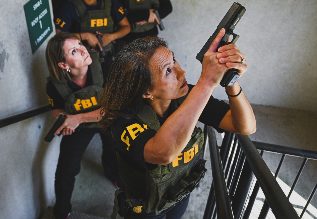 Two female special agents from the FBI Houston Division perform tactical skills training in a stairwell.