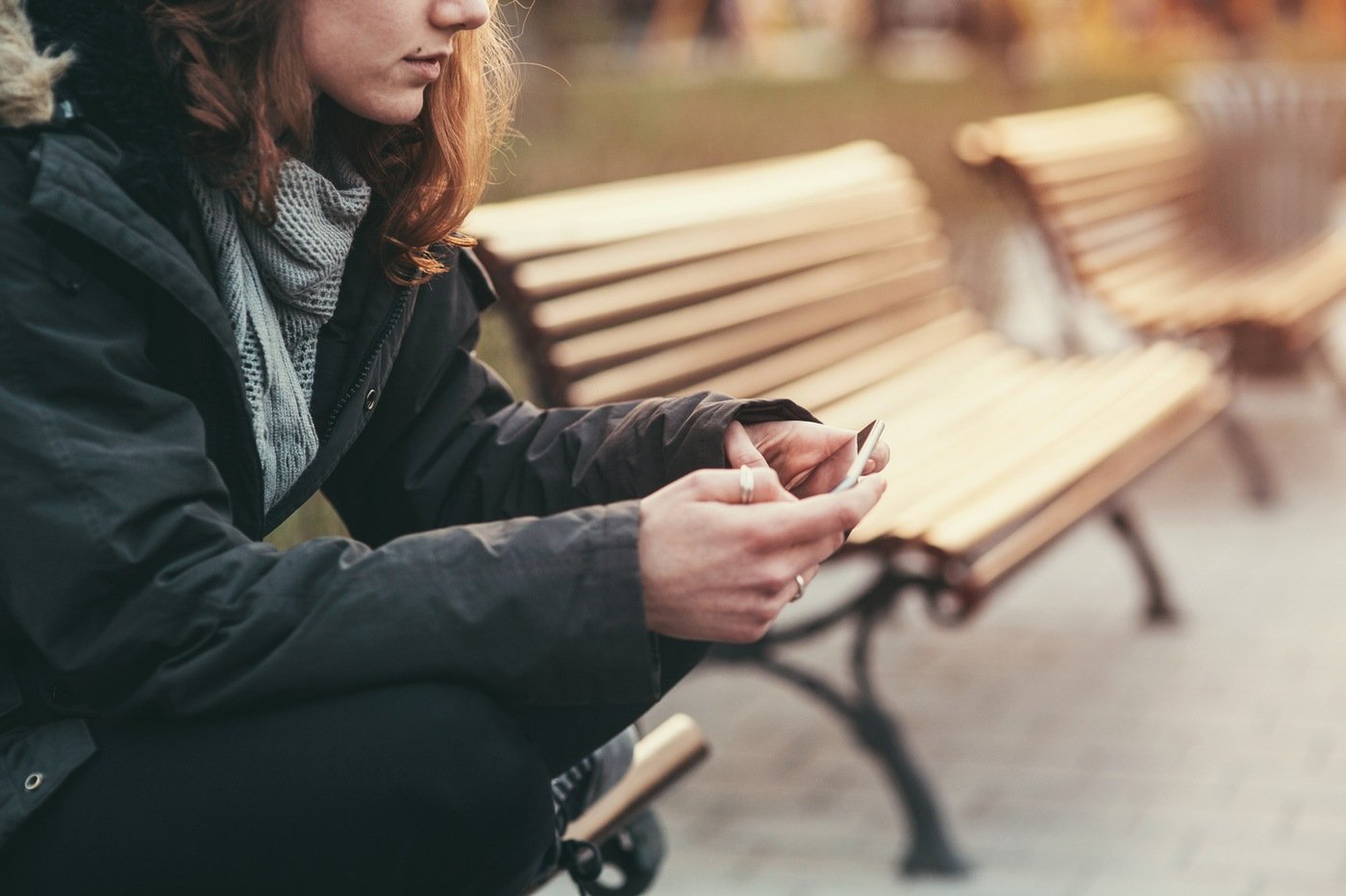 Girl Sitting on Bench Holding Cell Phone (Stock Image)