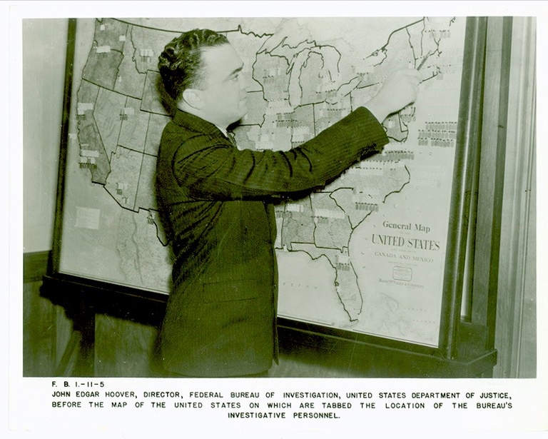 J. Edgar Hoover at a map of the United States.