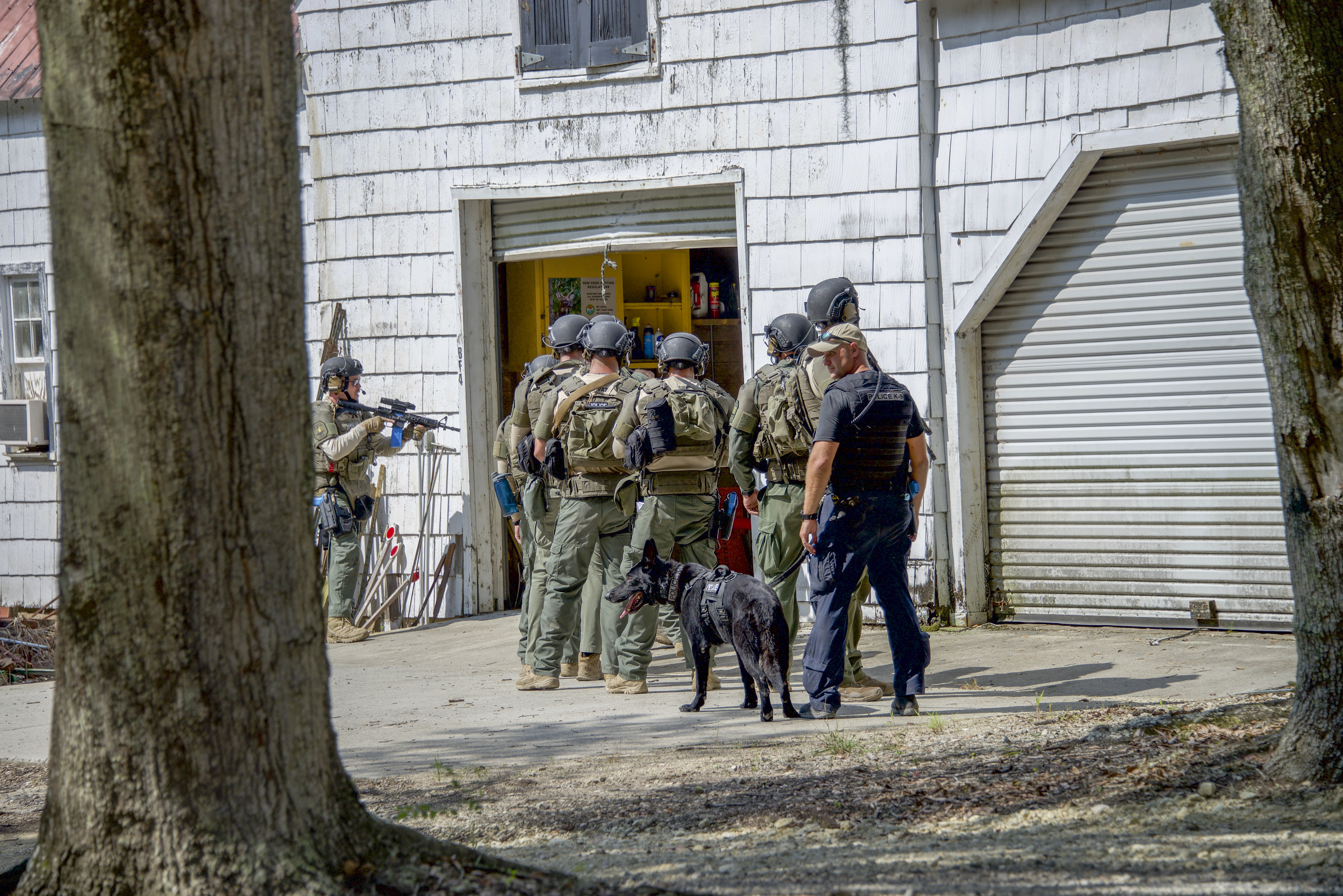 Charleston Police SWAT team members with a police dog enter a barn during a Hostage Rescue Team (HRT) training exercise held August 5-7, 2019, in Charleston, South Carolina.
