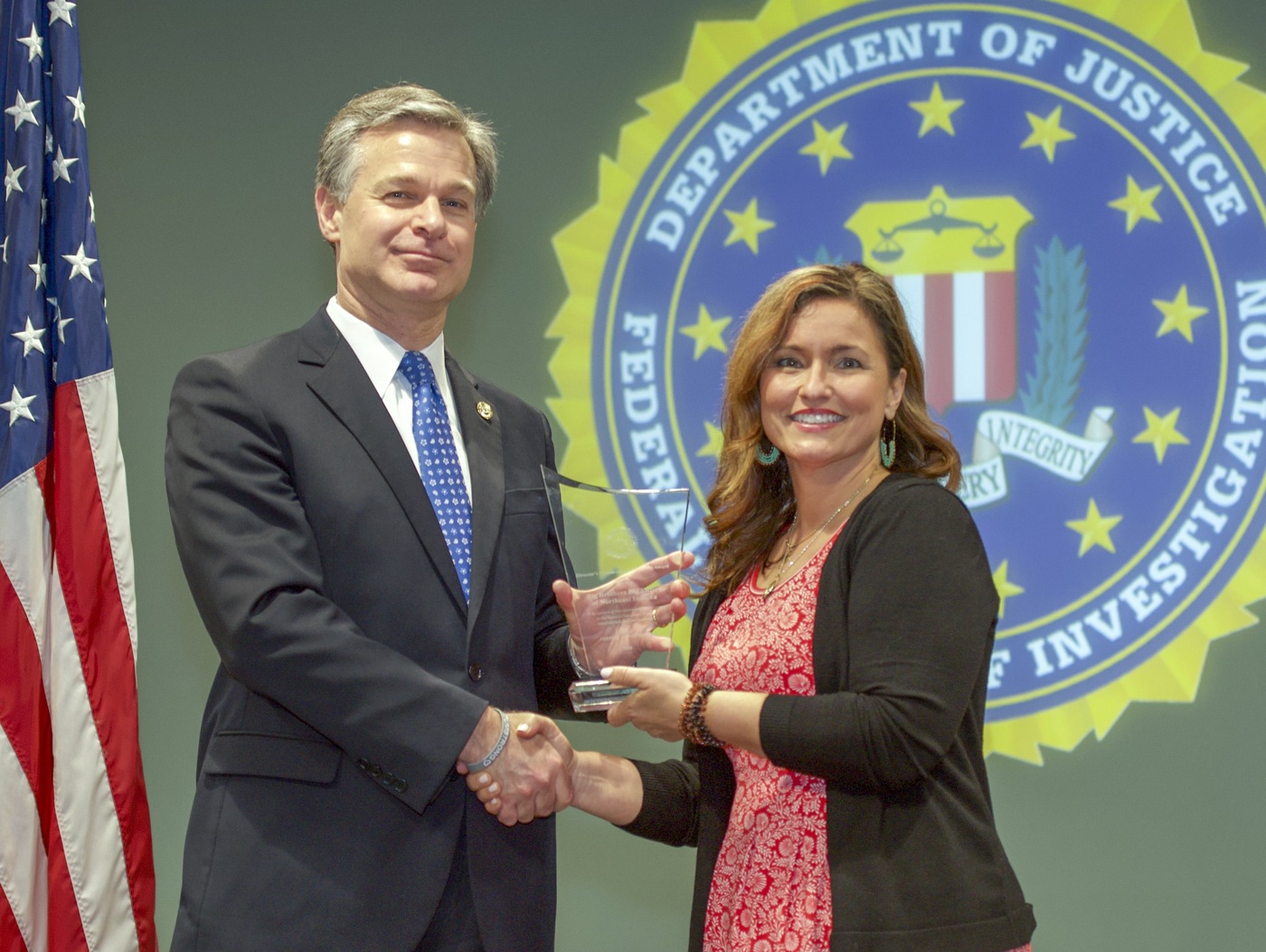 FBI Director Christopher Wray presents Indianapolis Division recipient Big Brothers Big Sisters of Northeast Indiana (represented by Josette Rider) with the Director’s Community Leadership Award (DCLA) at a ceremony at FBI Headquarters on May 3, 2019.