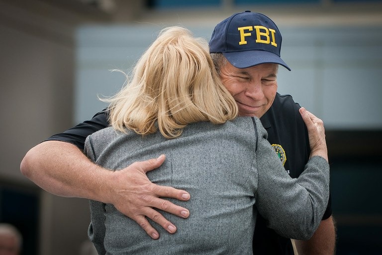 Pete Miller (right), president of the FBI Jacksonville Citizens Academy Alumni Association, receives a hug to go along with a recognition award from Ann Dugger, executive director of the Justice Coalition, during the first annual FAN luncheon.