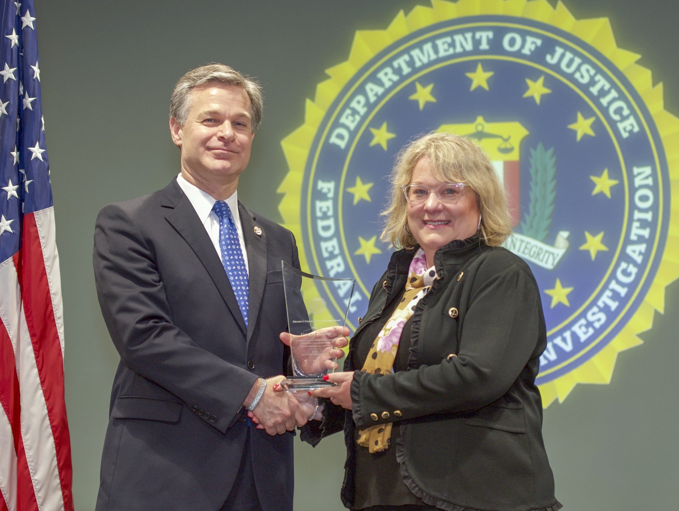 FBI Director Christopher Wray presents Kansas City Division recipient Going to the Dogs (represented by Donna Wilson) with the Director’s Community Leadership Award (DCLA) at a ceremony at FBI Headquarters on May 3, 2019.