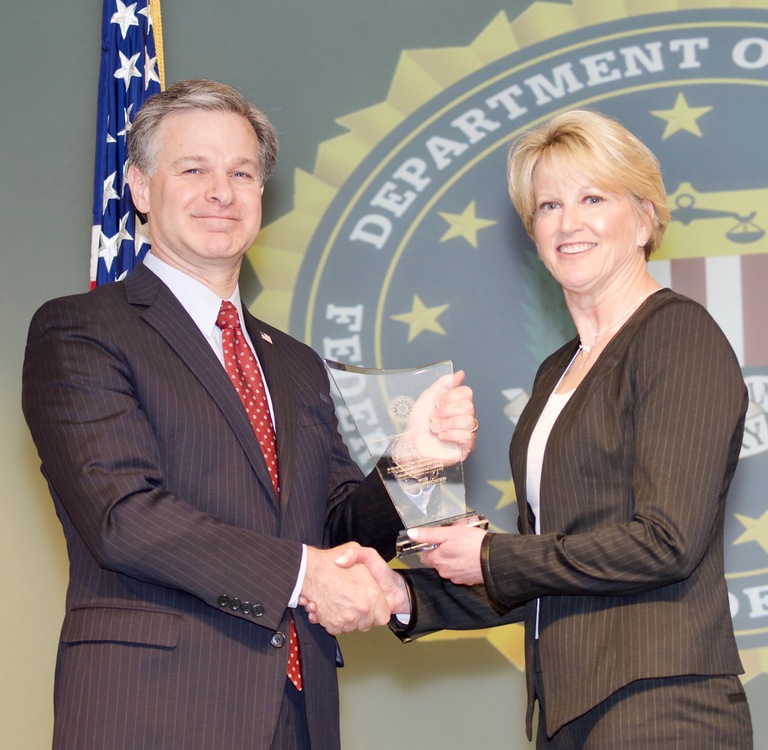 FBI Director Christopher Wray presents Knoxville Division recipient Karen Pershing with the Director’s Community Leadership Award (DCLA) at a ceremony at FBI Headquarters on April 20, 2018.