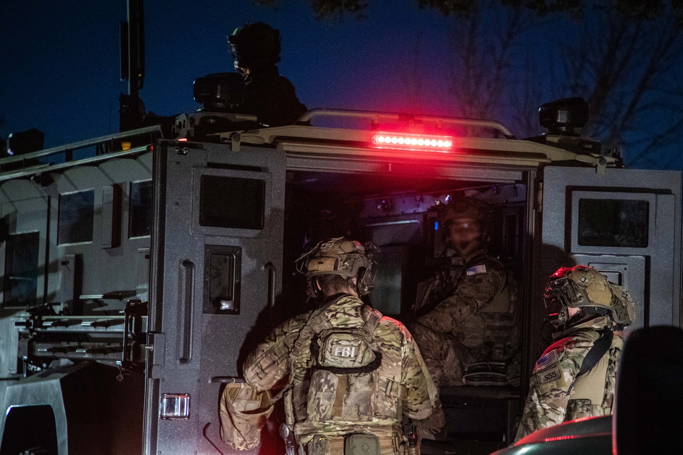 FBI SWAT officers load into a truck after the operation concluded.
