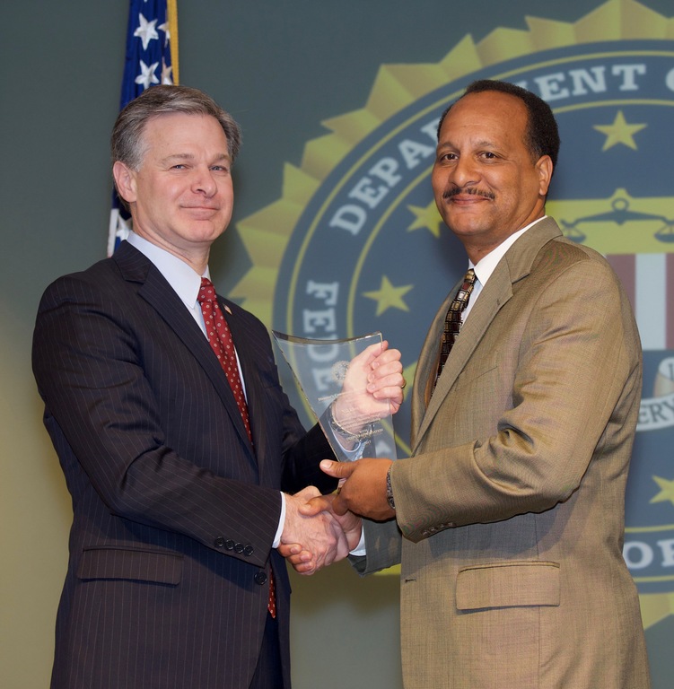 FBI Director Christopher Wray presents Mobile Division recipient Nikklos Kidd with the Director’s Community Leadership Award (DCLA) at a ceremony at FBI Headquarters on April 20, 2018.