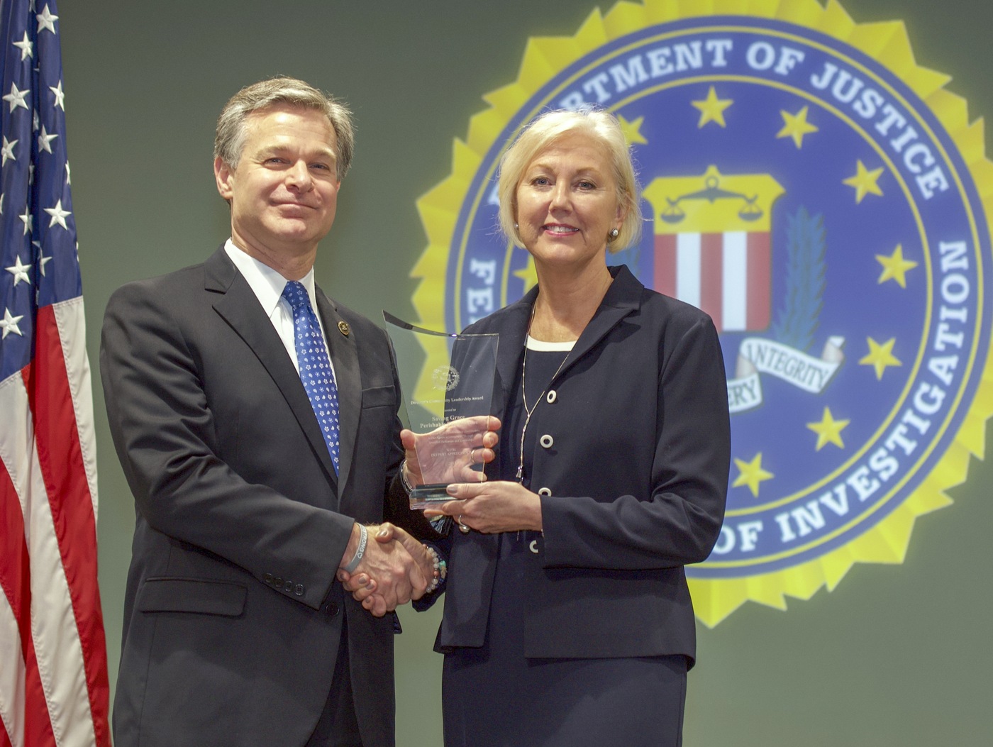 FBI Director Christopher Wray presents Omaha Division recipient Saving Grace Perishable Food Rescue (represented by Beth Ostdiek Smith) with the Director’s Community Leadership Award (DCLA) at a ceremony at FBI Headquarters on May 3, 2019.