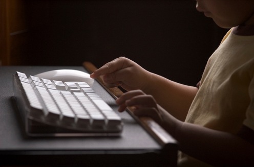 Child Typing on Computer Keyboard