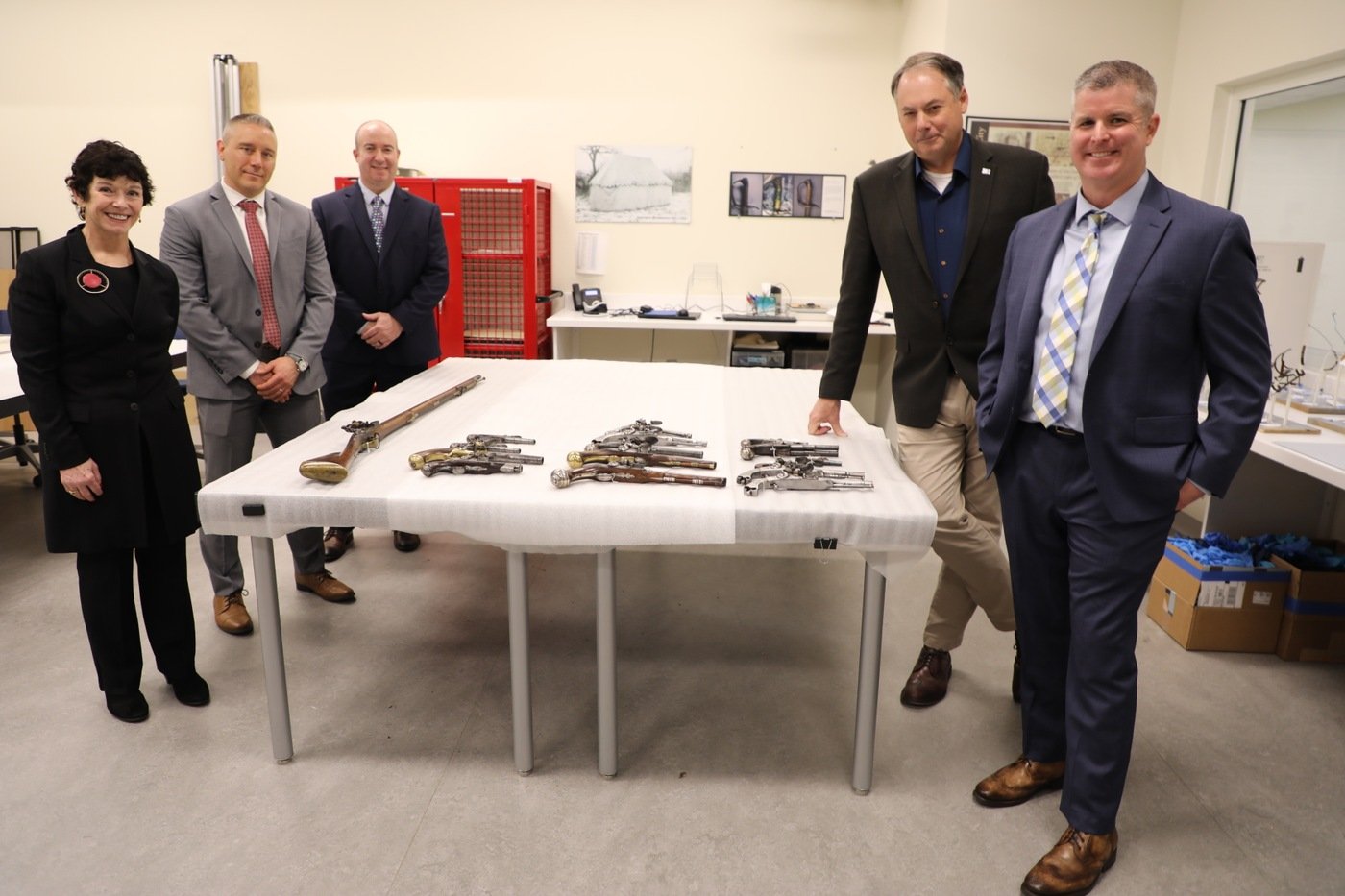 (From left to right) Assistant U.S. Attorney K.T. Newton of the U.S. Attorney's Office for the Eastern District of Pennsylvania, FBI Philadelphia Special Agent Jake Archer,  Detective Andy Rathfon of the Upper Merion Township Police Department in Pennsylvania, Museum of the American Revolution President and CEO Scott Stephenson, and Upper Merion Township Police Detective Brendan Dougherty pose alongside Revolutionary War-era firearms they collectively helped recover. The photo was captured in January 2024 at the museum in Philadelphia.