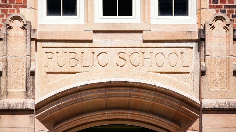 Stock image depicting the front of a public school building.