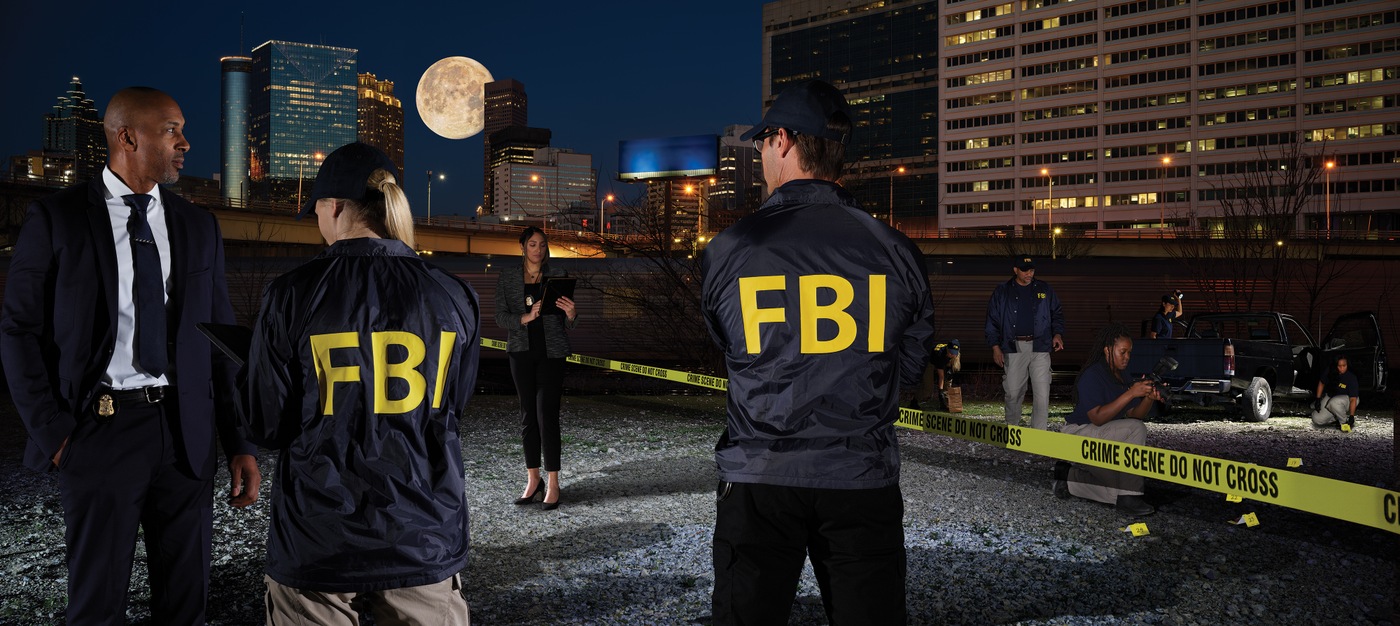 Image of FBI employees standing at a crime scene at night.