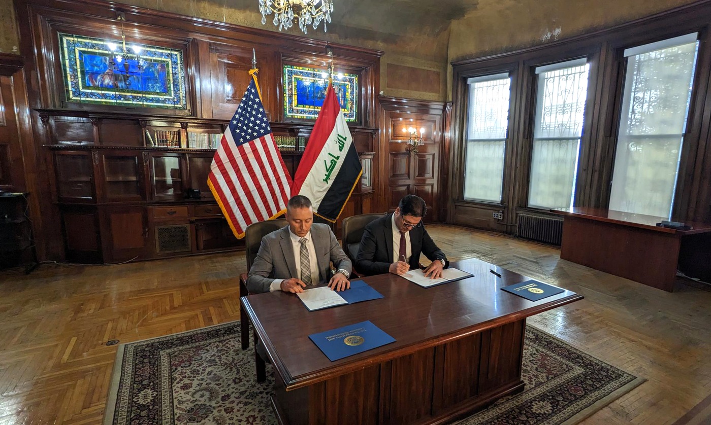 Special Agent Jake Archer and Silwan Sinarjee, chargé d'affaires at the Embassy of the Republic of Iraq, sign documents marking the return of a stolen artifact on March 8, 2023.
