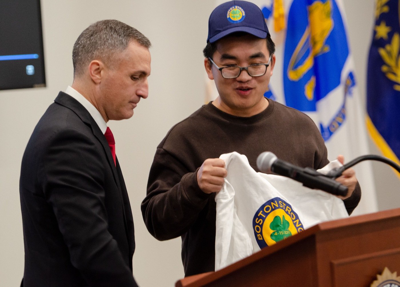 FBI Boston Special Agent in Charge Joseph Bonavolonta presents Dun Meng with items of appreciation during during a remembrance event in March 2023 marking the 10-year anniversary of the Boston Marathon bombings. Meng was kidnapped by the bombers in 2013. 