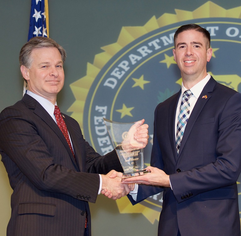 FBI Director Christopher Wray presents Sacramento Division recipient the Sacramento LGBT Community Center (represented by David Heitstuman) with the Director’s Community Leadership Award (DCLA) at a ceremony at FBI Headquarters on April 20, 2018.
