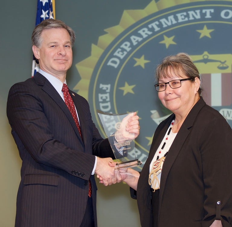 FBI Director Christopher Wray presents Salt Lake City Division recipient Bernie LaSarte with the Director’s Community Leadership Award (DCLA) at a ceremony at FBI Headquarters on April 20, 2018.