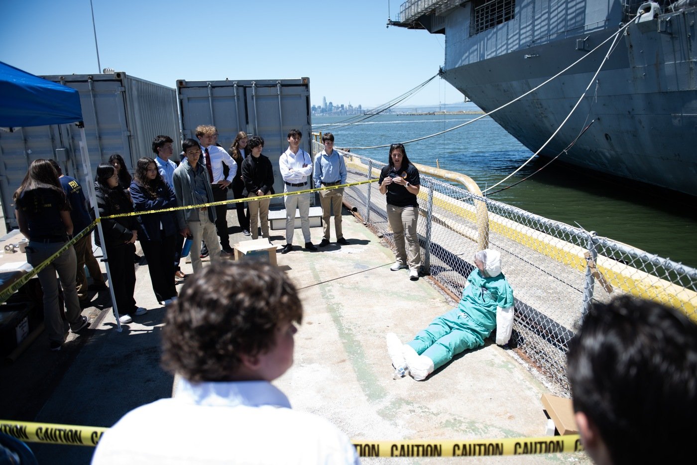 The Evidence Response Team (or ERT) lead teaches students about evidence collection in a mock crime scene on the pier during FBI San Francisco's Summer 2023 Teen Academy, held in Alameda, California.