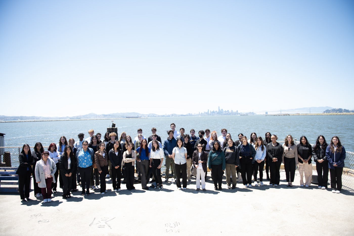 The FBI San Francisco Summer 2023 Teen Academy class poses on the pier in front of the San Francisco skyline and San Francisco Bay Bridge.