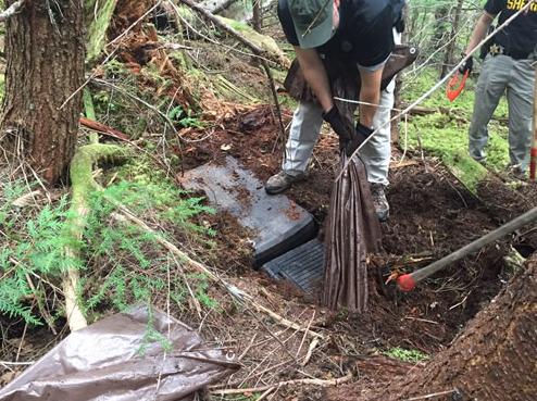 Cache of criminal accessories and stolen goods hidden by bank robber Bradley Steven Robinett in the Olympic National Forest and located by investigators on May 22, 2015.