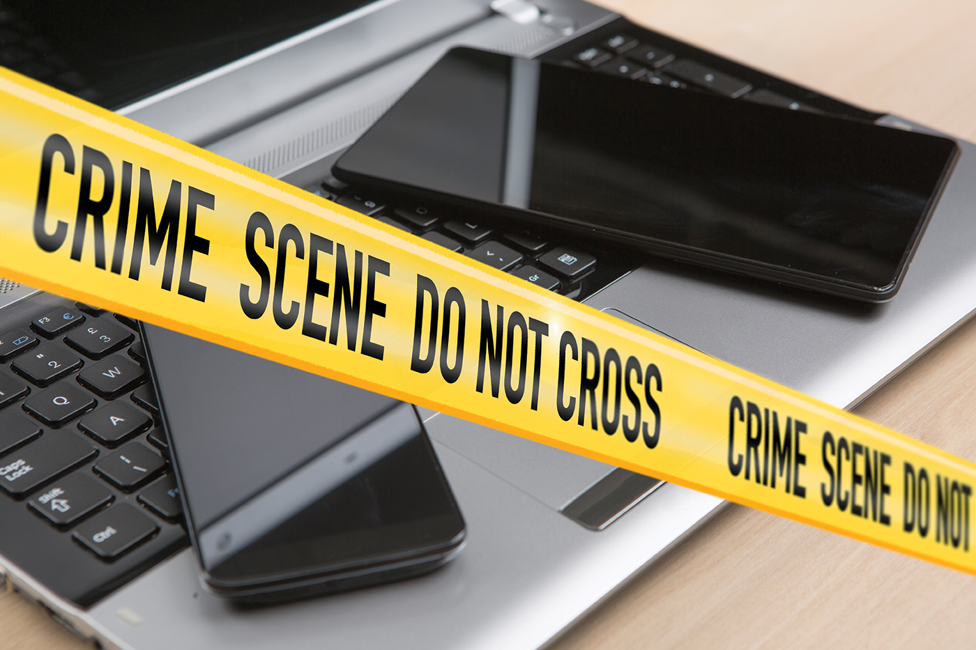 Crime Scene Tape in Front of Electronic Devices (Stock Image)