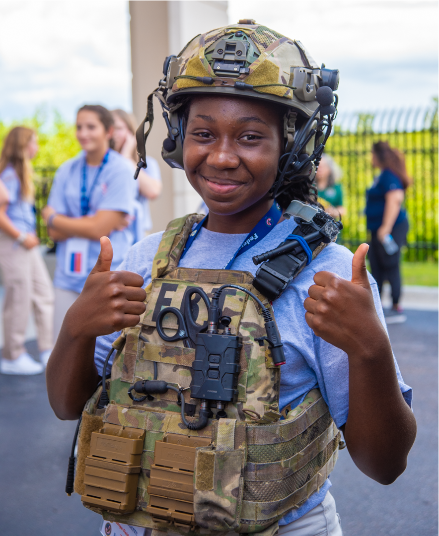 A student at the most recent Teen Academy hosted by FBI Tampa poses wearing HRT gear.