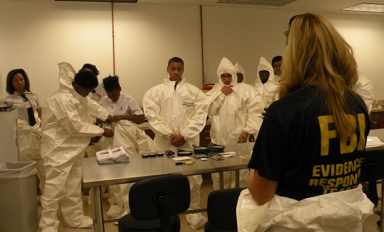 A member of the FBI Las Vegas Evidence Response Team instructs participants in the 2014 Teen Academy on evidence collection techniques.