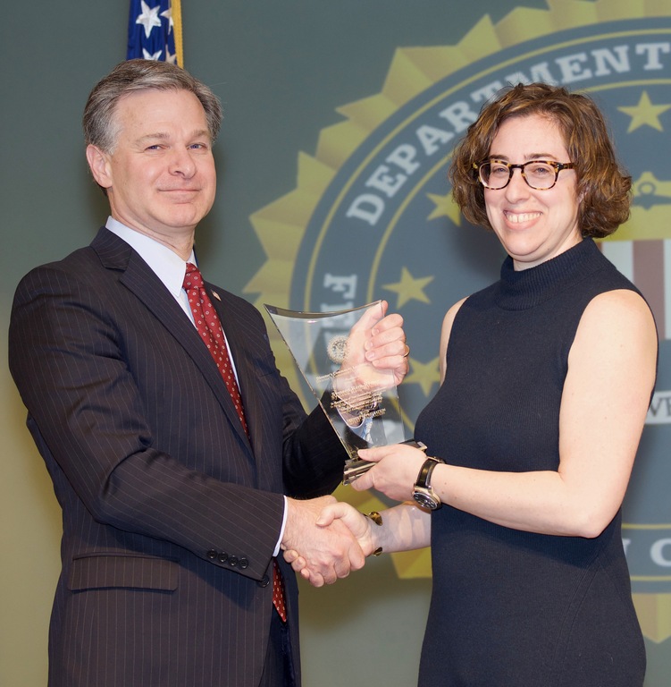 FBI Director Christopher Wray presents Washington Field Office Division recipient Symeon Rom-Rymer with the Director’s Community Leadership Award (DCLA) at a ceremony at FBI Headquarters on April 20, 2018.