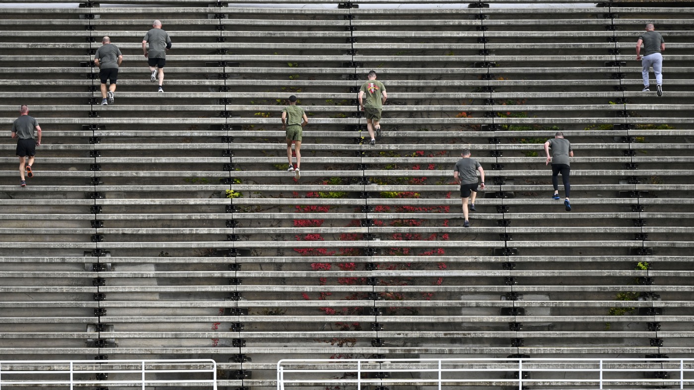 FBI National Academy students and Wounded Warrior Regiment Marines run up and down bleachers.