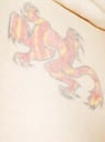 Tattoo of chameleon on her left hip